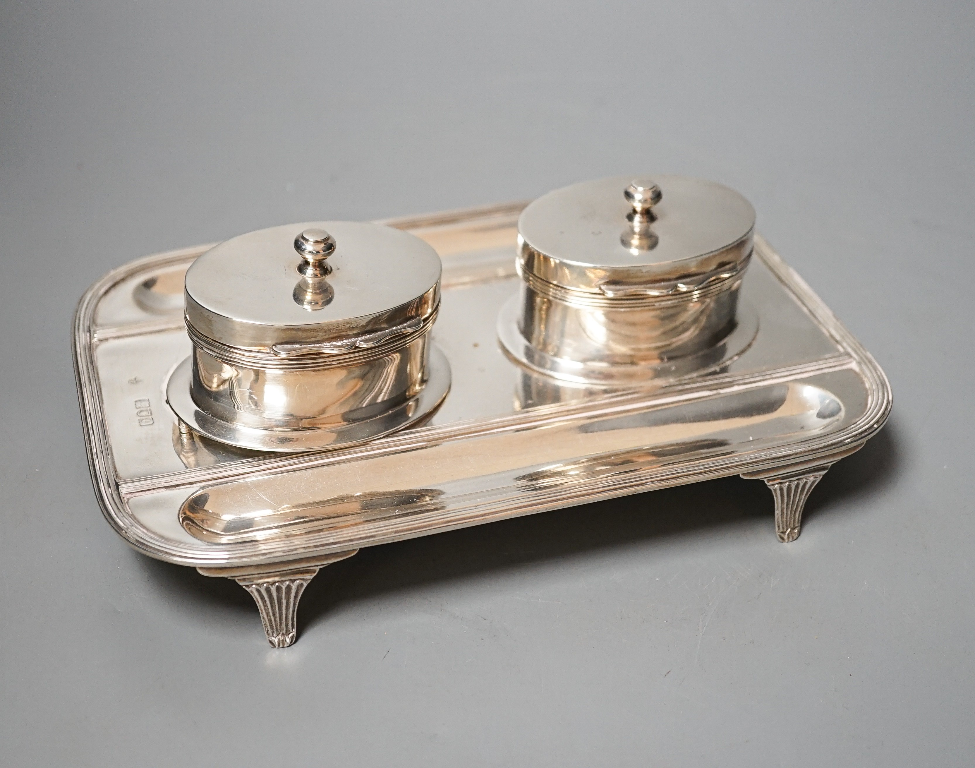 A late Victorian silver rounded rectangular inkstand, with two wells and two pen recesses, Charles Stuart Harris, London, 1900, 22.3cm, gross 20oz.